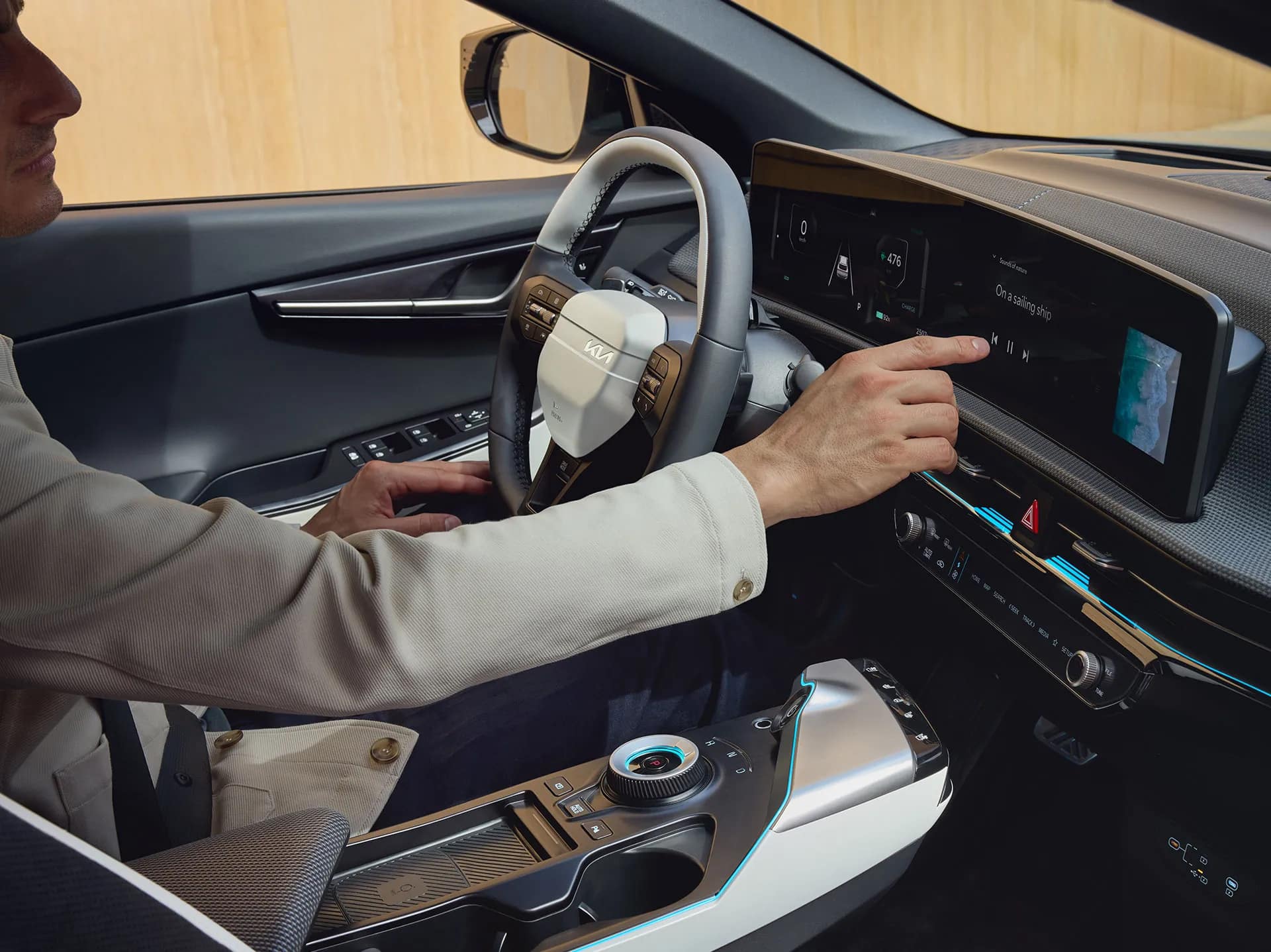 Auf diesem Bild ist eine Person im Innenraum eines modernen Autos zu sehen, die das digitale Infotainmentsystem bedient.