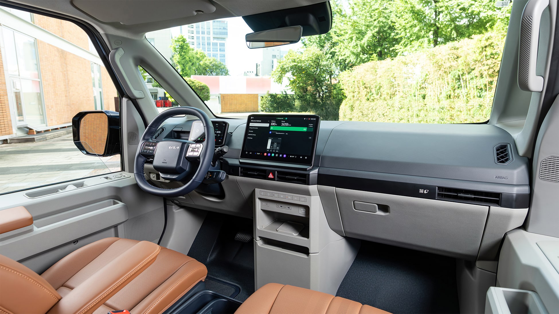 Moderner, funktionaler Innenraum des Kia PV5 Passenger Elektro-Vans mit großem Zentraldisplay und hellbraunen Sitzen