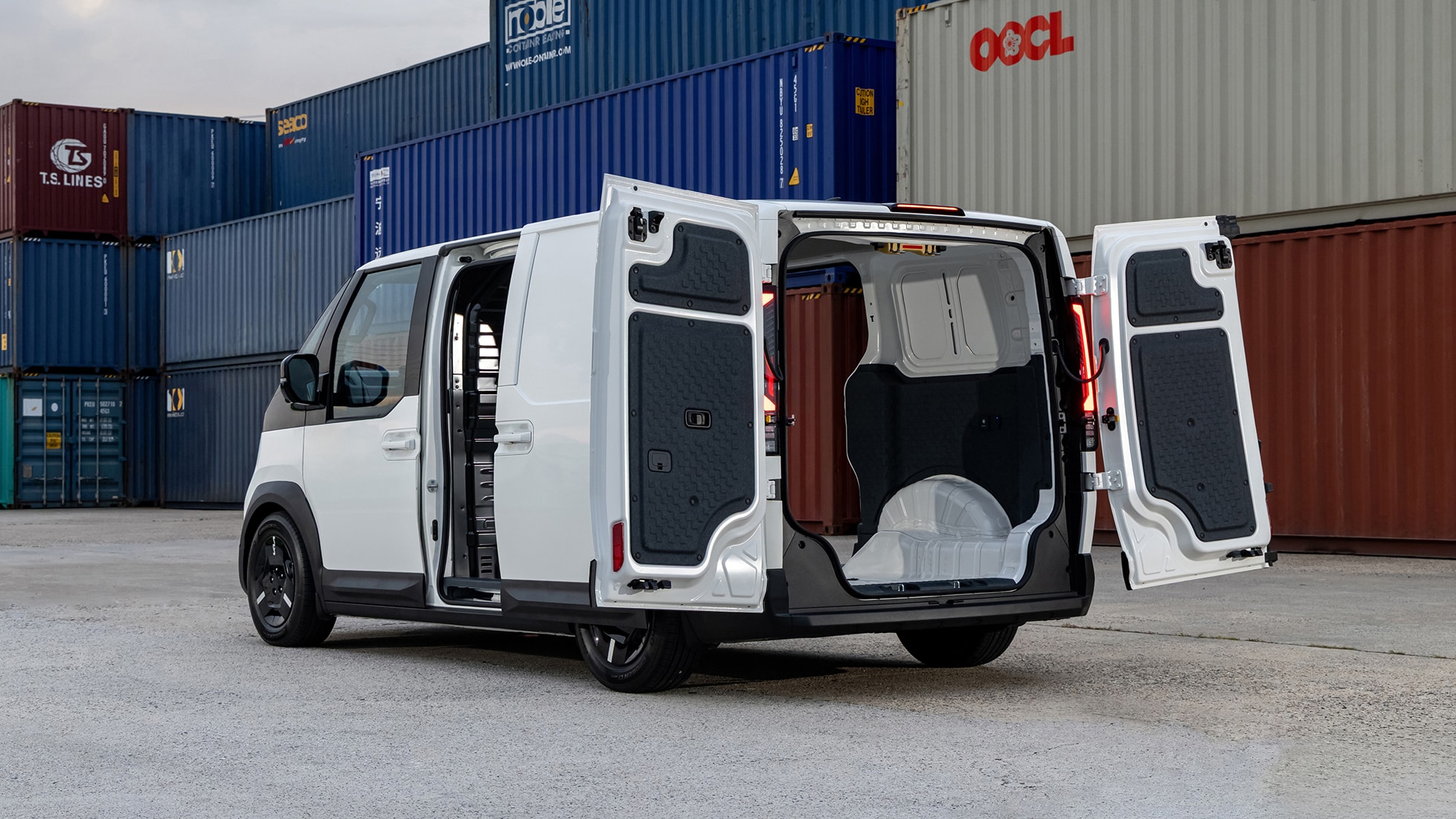 Kia PV5 Cargo Elektro-Van Exterior: Heckansicht mit weit geöffneten Flügeltüren und Einblick in den Laderaum vor Logistik-Containern.