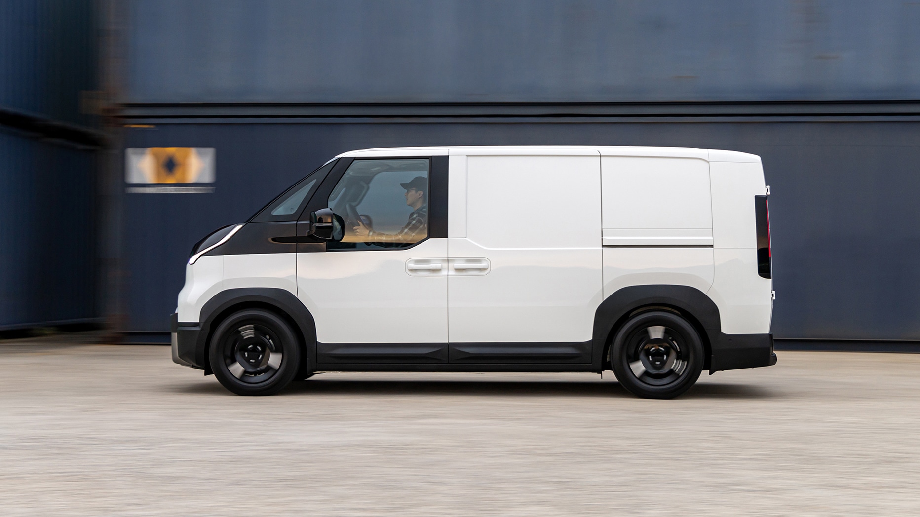 Seitenansicht des Kia PV5 Cargo in Weiß  vor modernem Gebäude