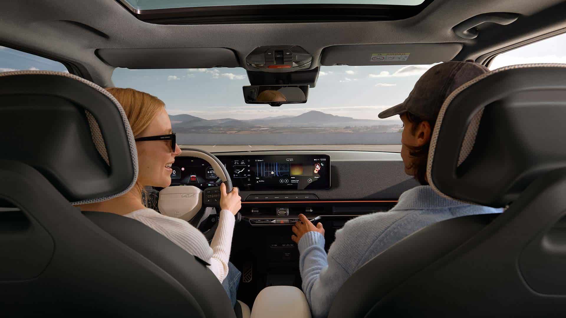 Innenraum des Kia EV2  Elektro-SUV mit Panoramadisplay und Blick auf Fahrer und Beifahrer.